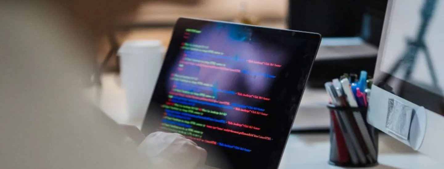 A developer writing code on a laptop